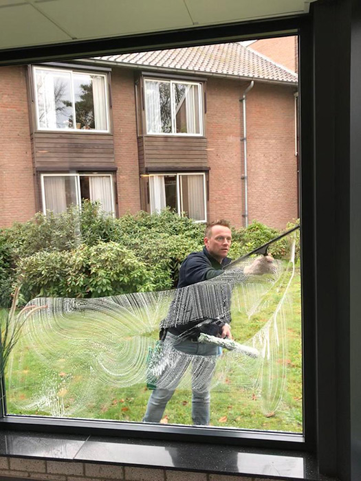 angel nellen maakt een raam schoon bij verzorgingstehuis