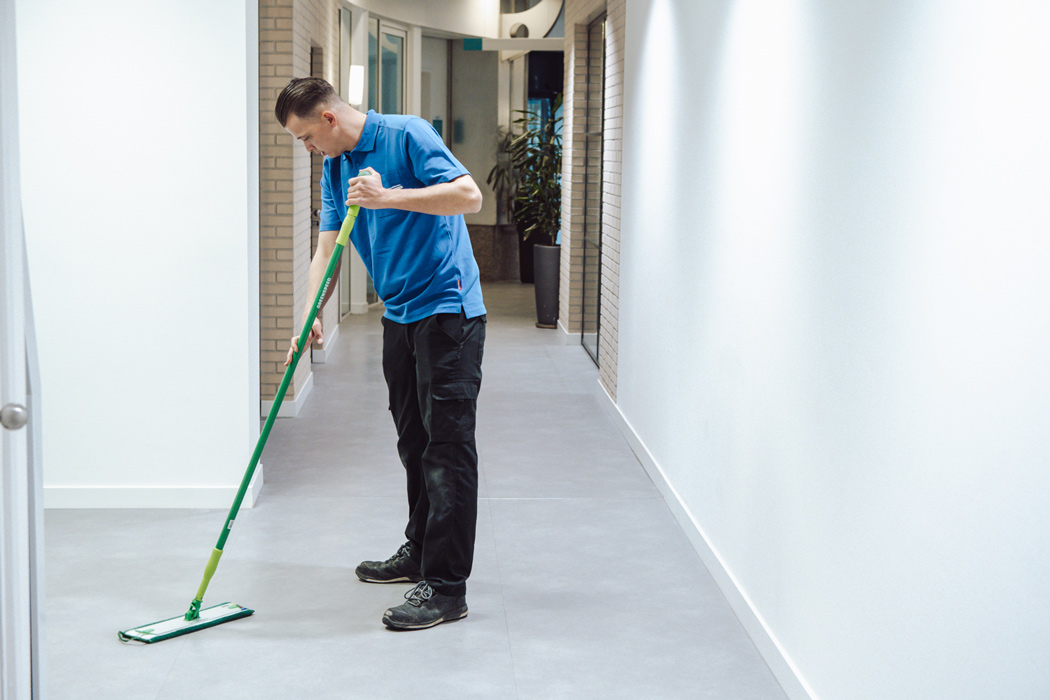 medewerker van nellen dweilt een vloer