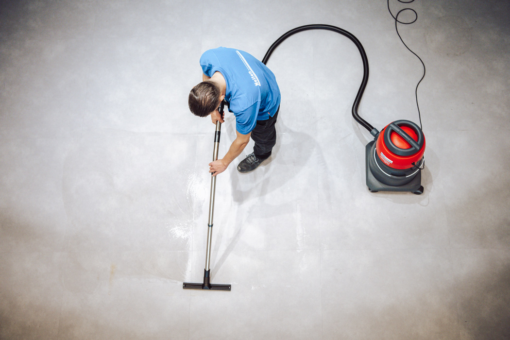 marmoleum schoongemaakt door medewerker van nelen met stofzuiger